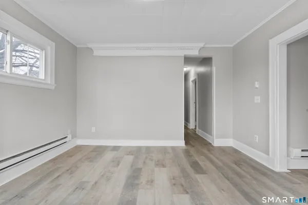 a view of empty room with wooden floor