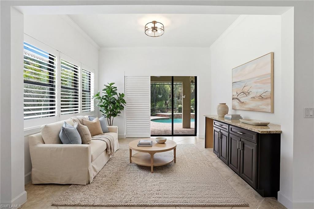 9436 Whooping Crane Way Naples, FL 34120 - Photo 12 of 32 a living room with furniture and a table