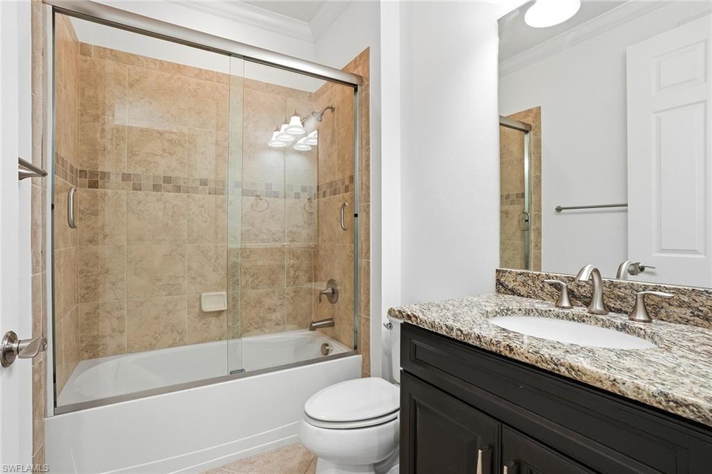 9436 Whooping Crane Way Naples, FL 34120 - Photo 15 of 32 a bathroom with a granite countertop sink toilet and shower