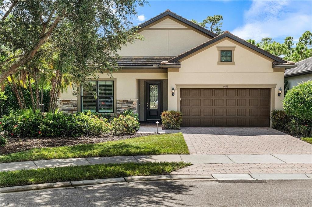 9436 Whooping Crane Way Naples, FL 34120 - Photo 23 of 32 a front view of a house with a yard and garage