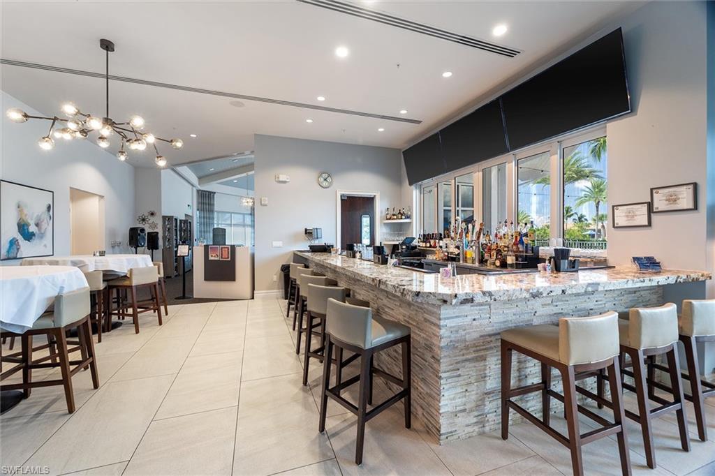 9436 Whooping Crane Way Naples, FL 34120 - Photo 27 of 32 a kitchen with a dining table chairs and view kitchen