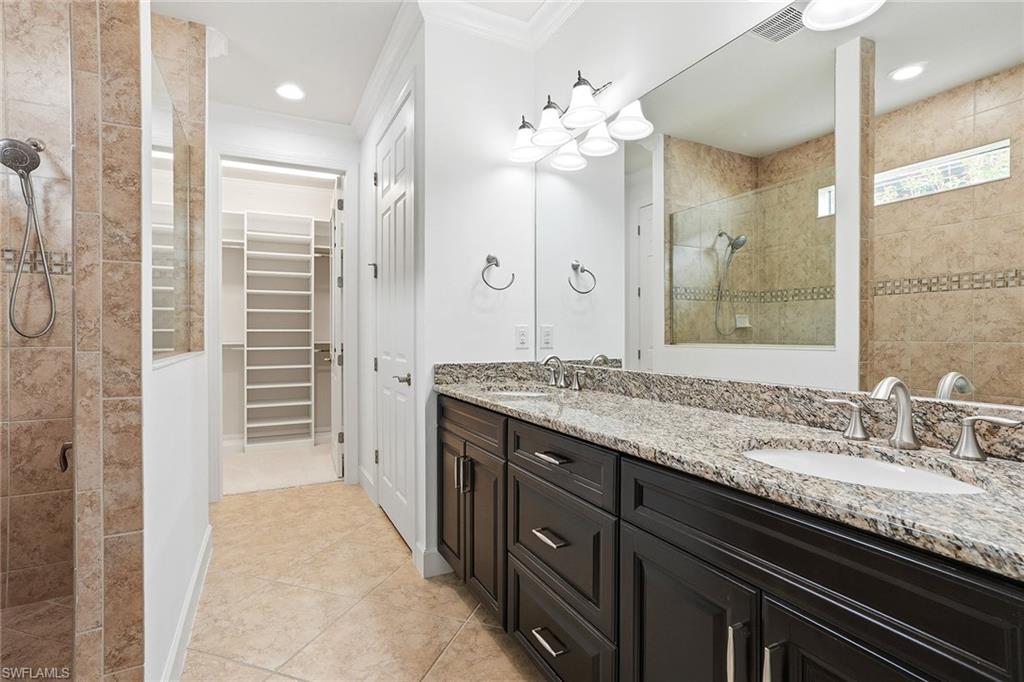 9436 Whooping Crane Way Naples, FL 34120 - Photo 10 of 32 a bathroom with a granite countertop sink a large mirror and a shower