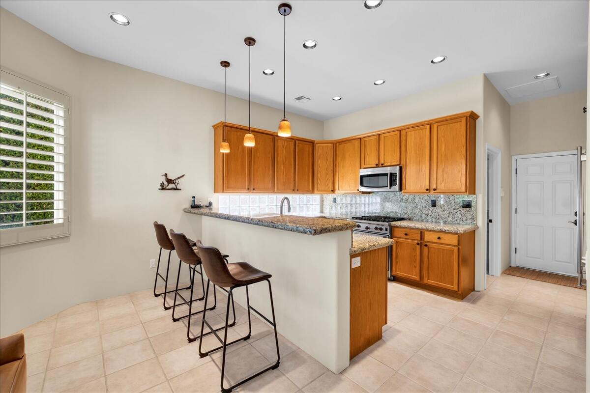 58 Payson Circle Palm Desert, CA 92211 - Photo 11 of 41 a kitchen with stainless steel appliances granite countertop a stove a sink island and a refrigerator