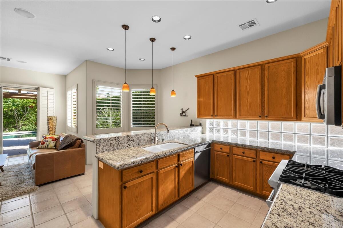 58 Payson Circle Palm Desert, CA 92211 - Photo 12 of 41 a kitchen with stainless steel appliances granite countertop a sink and a stove