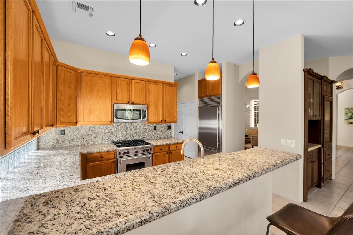 58 Payson Circle Palm Desert, CA 92211 - Photo 13 of 41 a kitchen with stainless steel appliances granite countertop a stove a sink and a refrigerator