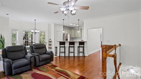 a living room with furniture a ceiling fan and a rug