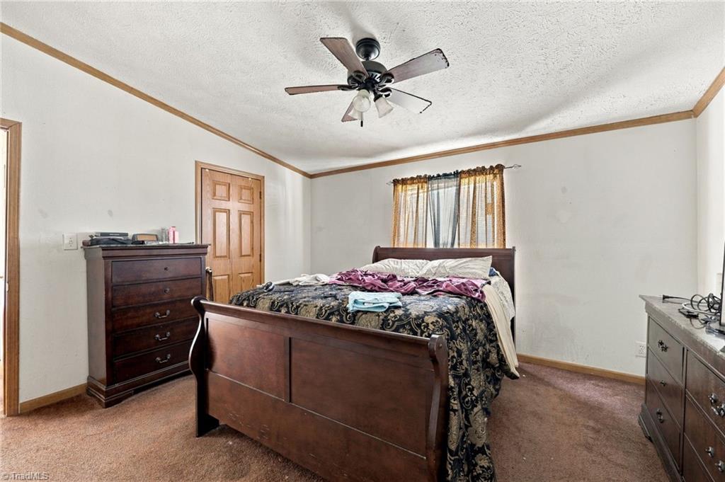 415 Talley Road Reidsville, NC 27320 - Photo 15 of 31 Spacious primary bedroom with ceiling fan and ample closet storage.
