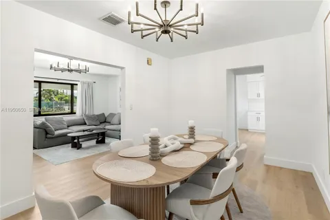 a view of a dining room with furniture and a chandelier