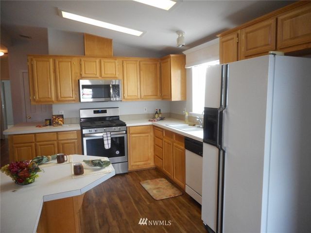 a kitchen with stainless steel appliances a refrigerator sink and microwave
