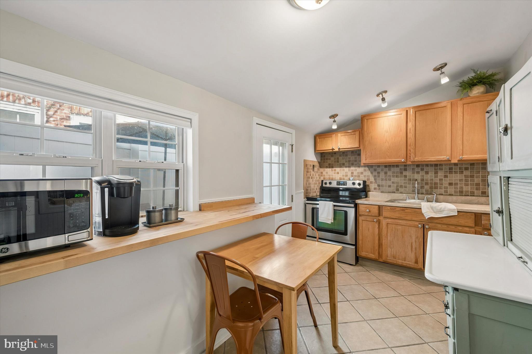 4509 Ritchie Street Philadelphia, PA 19127 - Photo 7 of 16 a kitchen with stainless steel appliances granite countertop a stove top oven a sink dishwasher a dining table and chairs with wooden floor