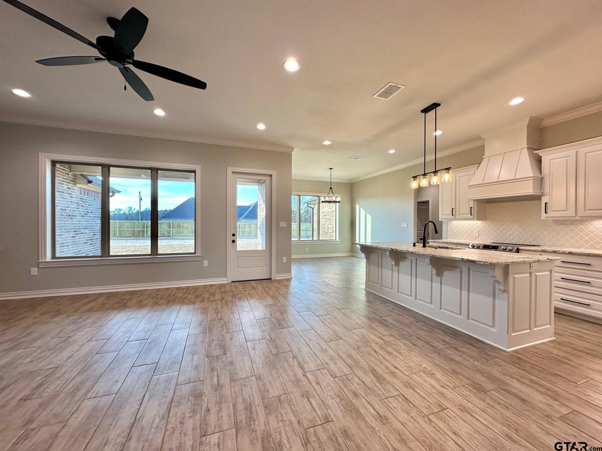 191 Brooks Drive Gladewater, TX 75647 - Photo 13 of 45 a open kitchen with kitchen island a island wooden floor appliances and a window