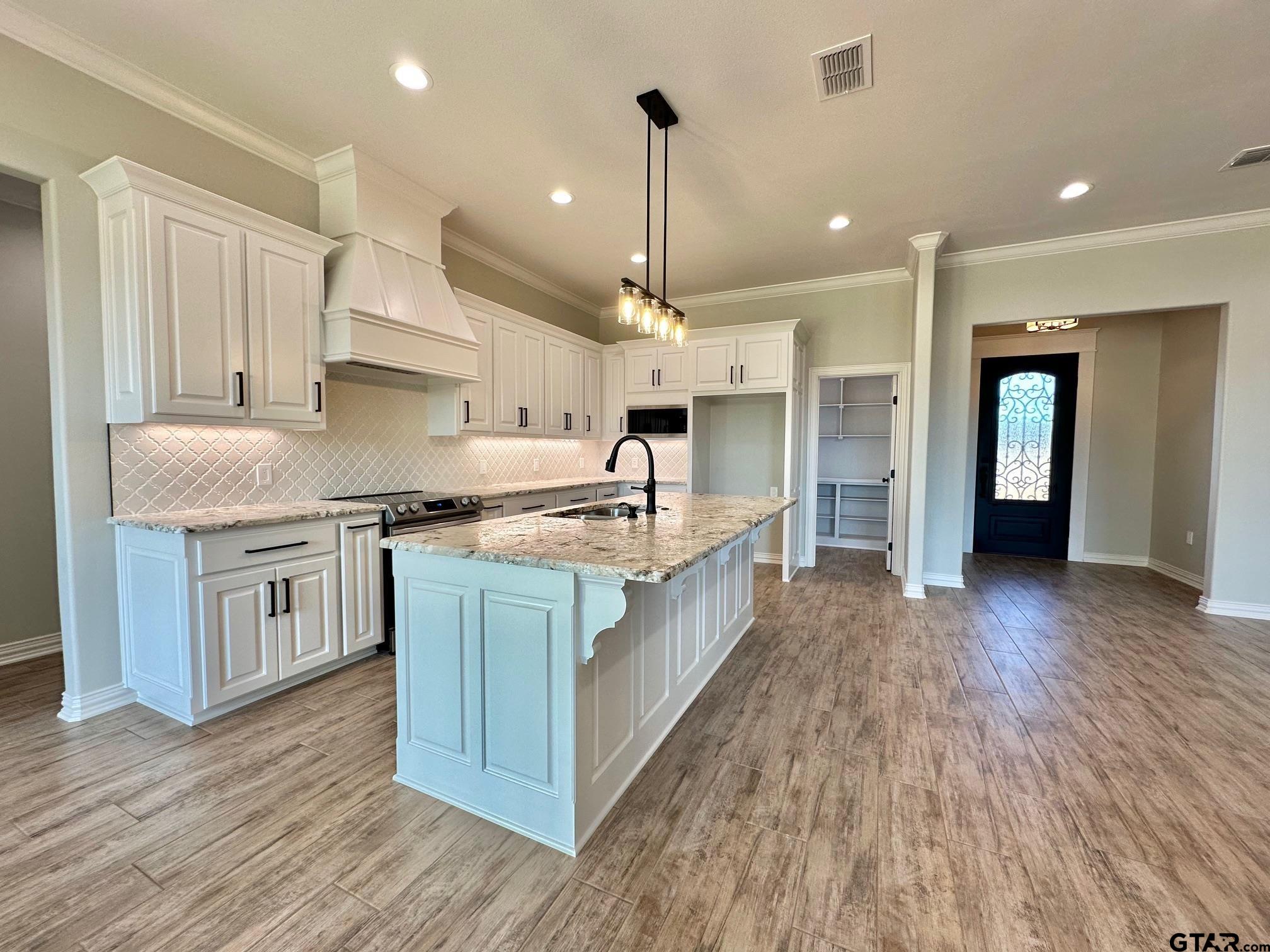 191 Brooks Drive Gladewater, TX 75647 - Photo 17 of 45 a kitchen with kitchen island granite countertop a sink refrigerator and cabinets