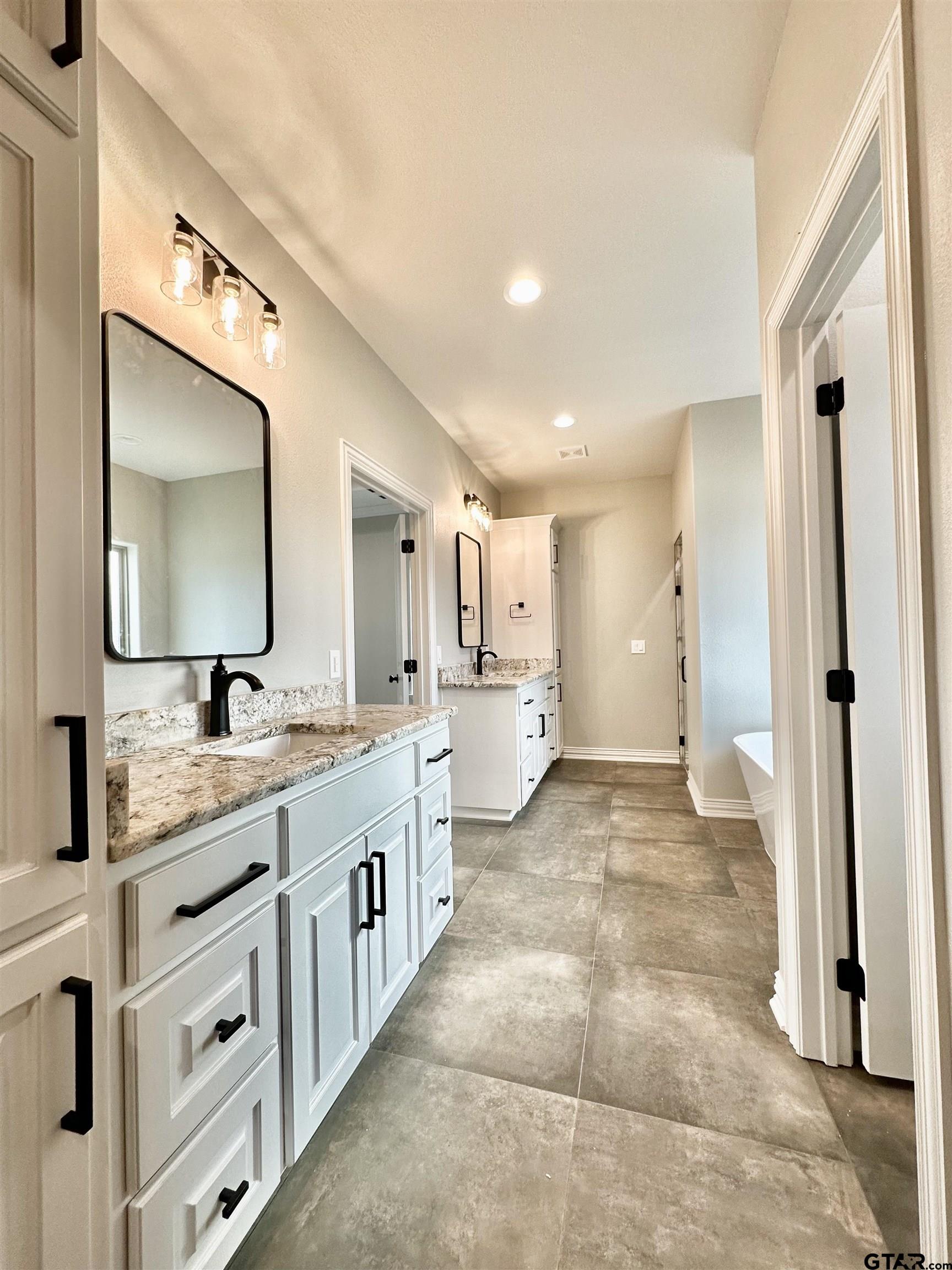 191 Brooks Drive Gladewater, TX 75647 - Photo 32 of 45 a spacious bathroom with a granite countertop sink mirror and a toilet
