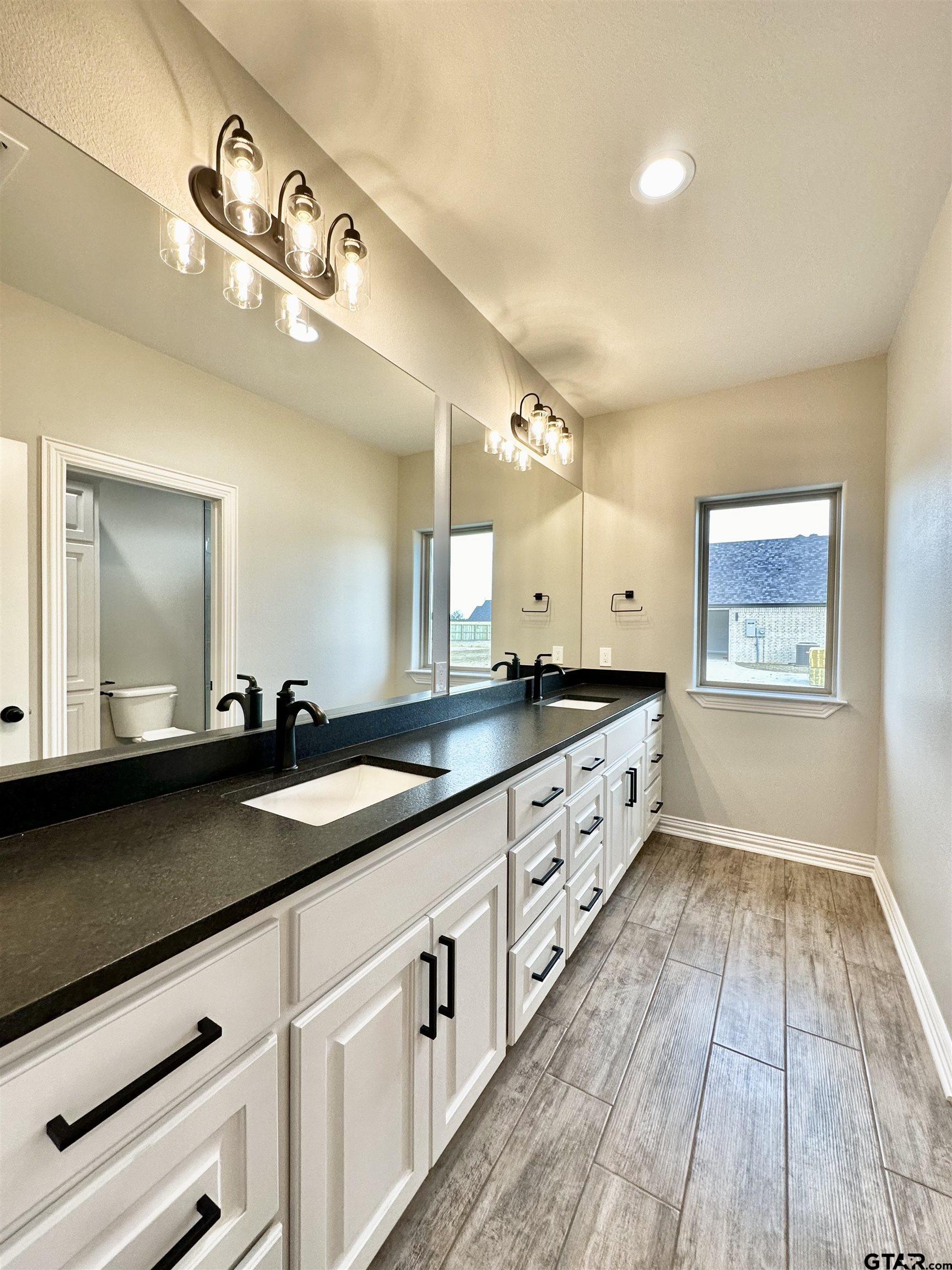 191 Brooks Drive Gladewater, TX 75647 - Photo 36 of 45 a large white kitchen with a large island wooden floor and stainless steel appliances