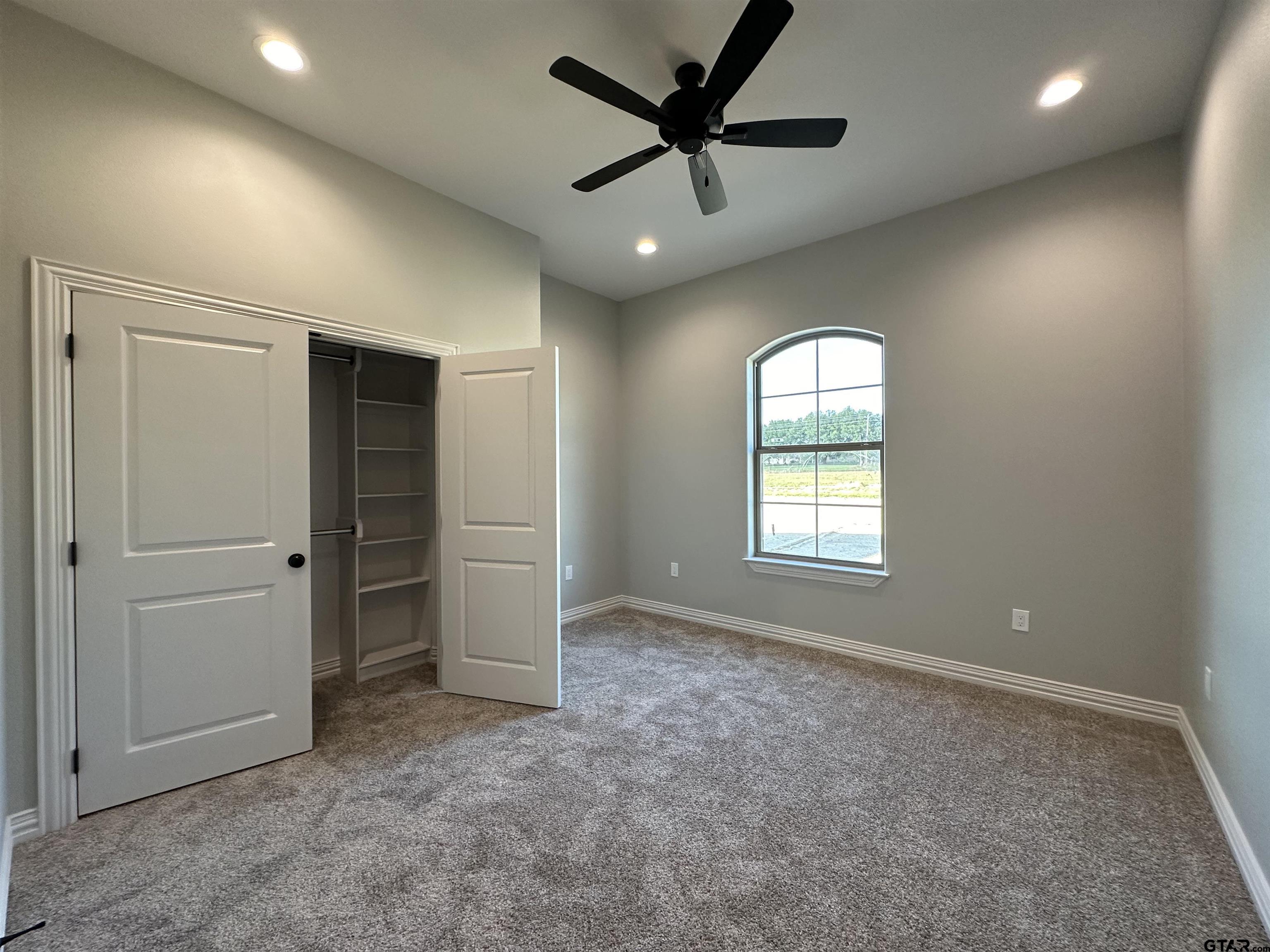 191 Brooks Drive Gladewater, TX 75647 - Photo 40 of 45 an empty room with windows and a ceiling fan