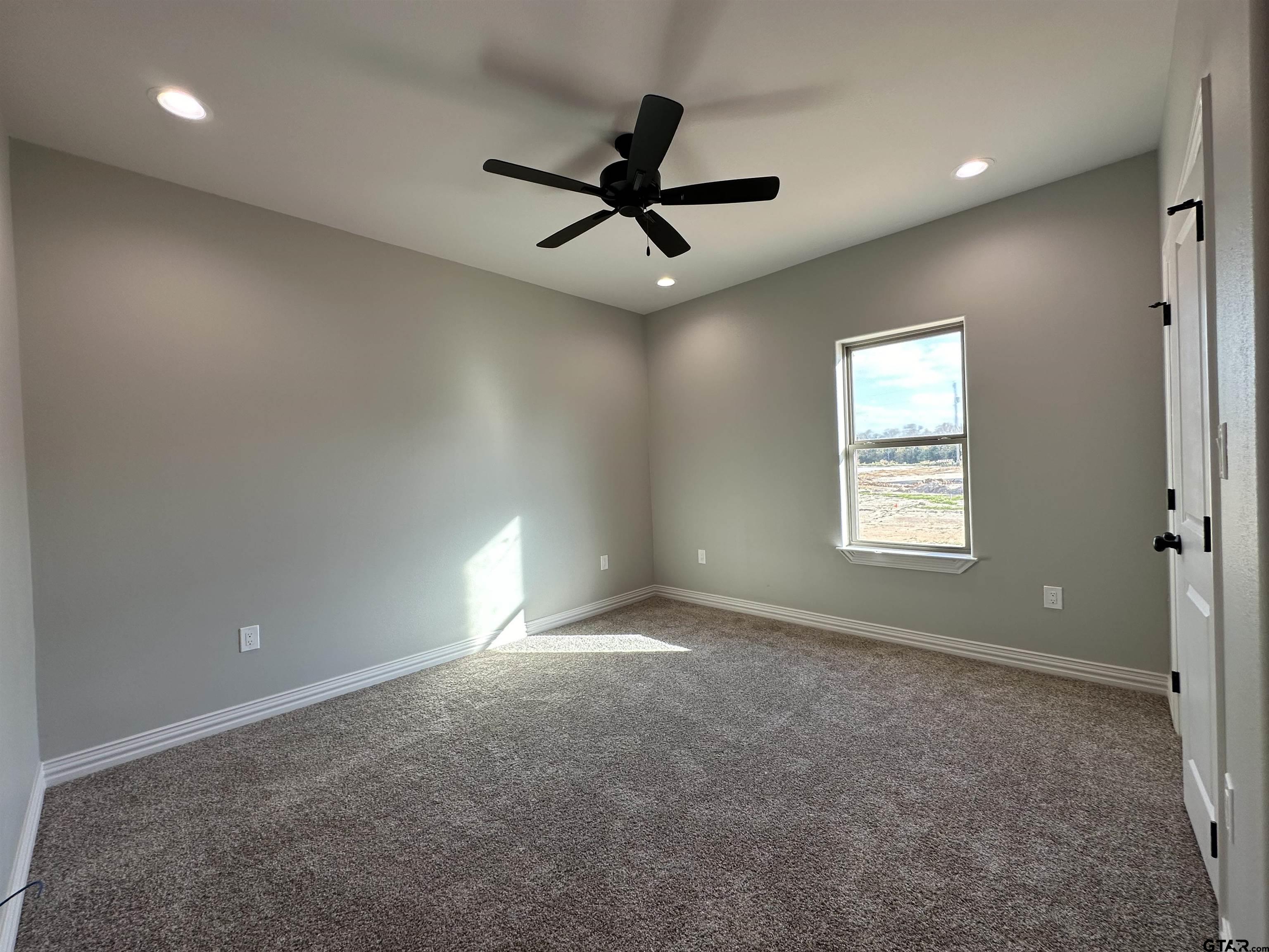 191 Brooks Drive Gladewater, TX 75647 - Photo 41 of 45 an empty room with ceiling fan and windows