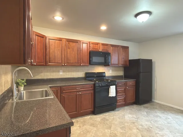 a kitchen with stainless steel appliances granite countertop a sink and a stove top oven