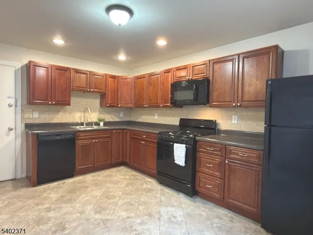a kitchen with stainless steel appliances granite countertop a refrigerator stove top oven and sink