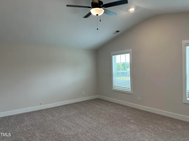 an empty room with a window and a fan