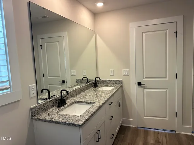 a bathroom with a granite countertop sink and a mirror