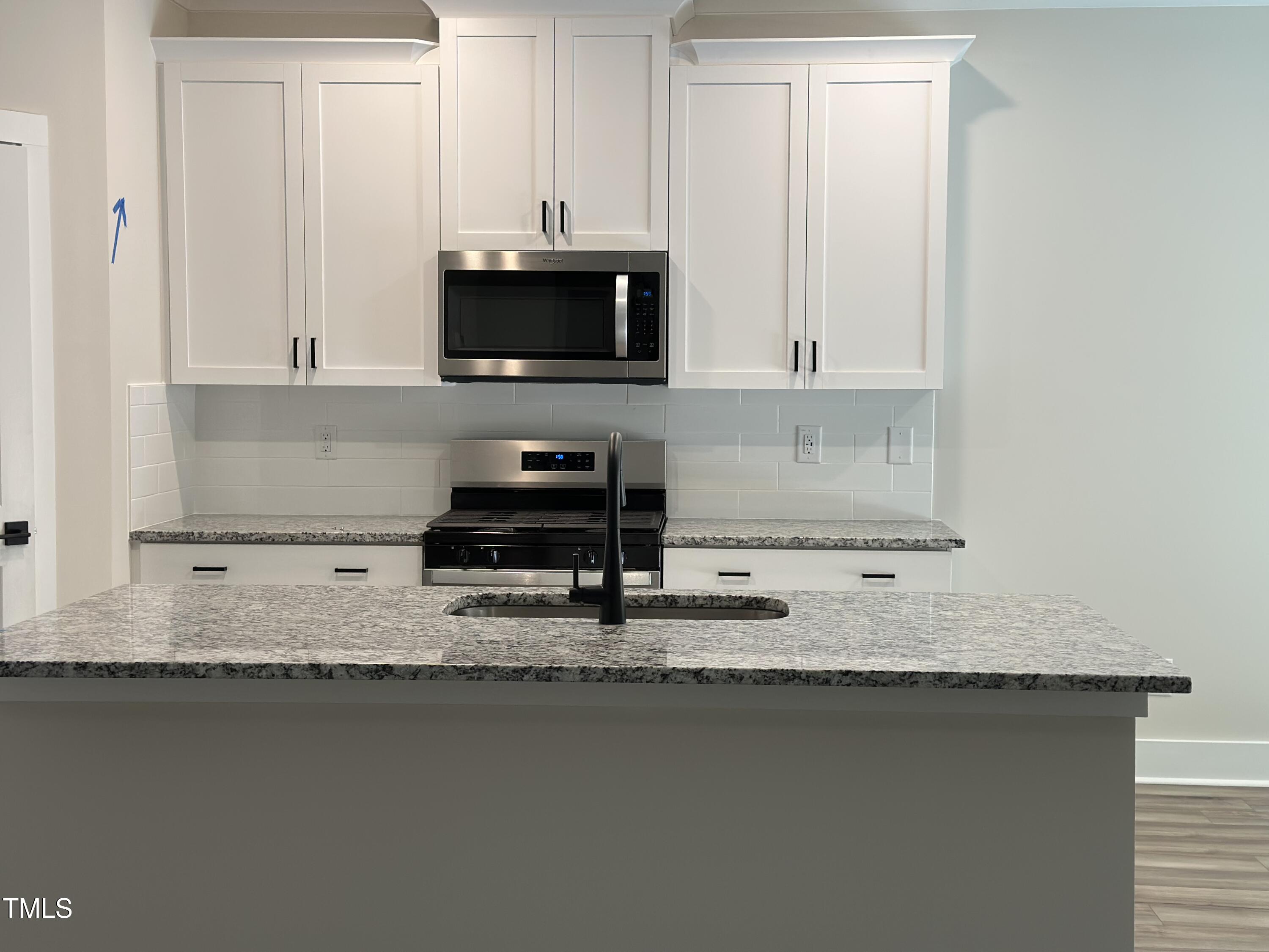 306 Shiloh Way Mebane, NC 27302 - Photo 8 of 33 a kitchen with granite countertop a sink a stove and white cabinets