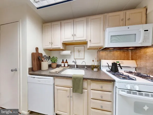 a kitchen with granite countertop a sink a stove and cabinets