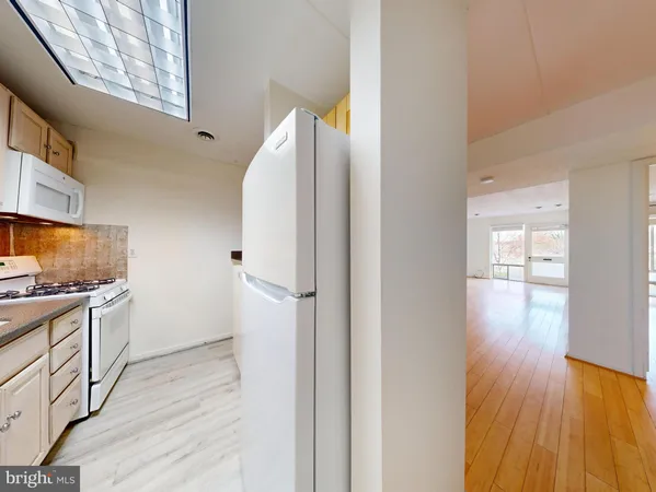 a view of a kitchen with wooden floor and electronic appliances
