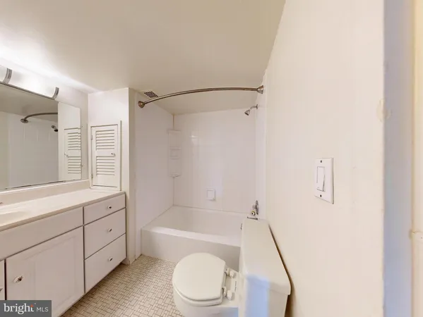 a bathroom with a granite countertop bathtub shower sink vanity and toilet