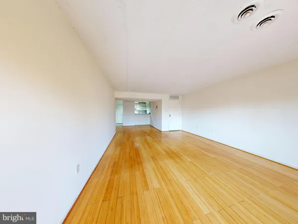 a bedroom with a bed and a wooden floor