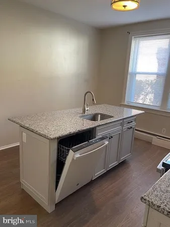 a kitchen with sink cabinets and wooden floor