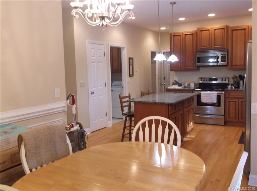 12450 Banks Road Mount Pleasant, NC 28124 - Photo 11 of 43 a kitchen with stainless steel appliances granite countertop a stove a refrigerator a kitchen island a couches and chairs with wooden floor