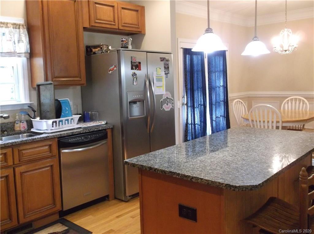 12450 Banks Road Mount Pleasant, NC 28124 - Photo 13 of 43 a kitchen with stainless steel appliances granite countertop a sink a refrigerator and a wooden cabinets