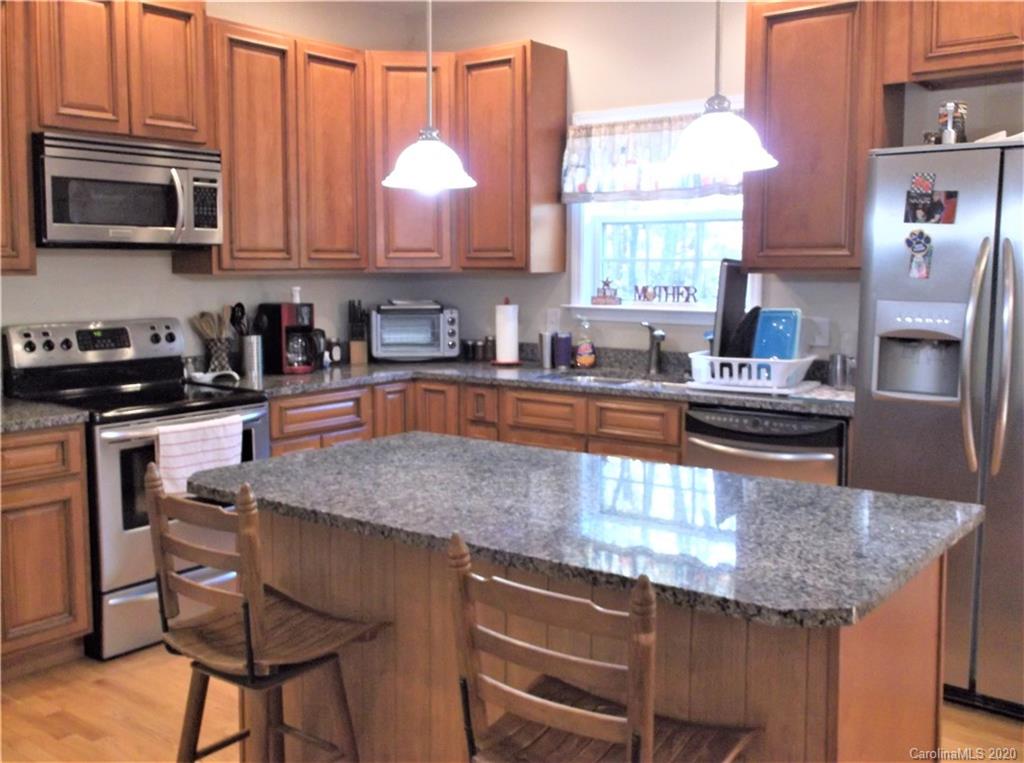 12450 Banks Road Mount Pleasant, NC 28124 - Photo 10 of 43 a kitchen with granite countertop a stove a sink and a microwave