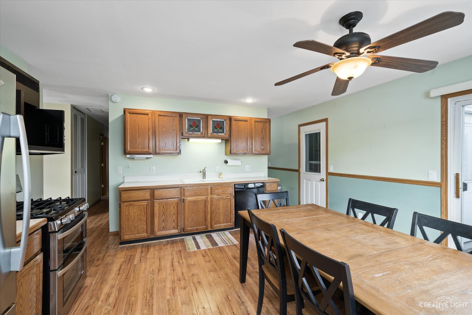 135 Heathgate Road Montgomery, IL 60538 - Photo 4 of 17 a kitchen with stainless steel appliances granite countertop a stove refrigerator a sink dishwasher a dining table and chairs with wooden floor