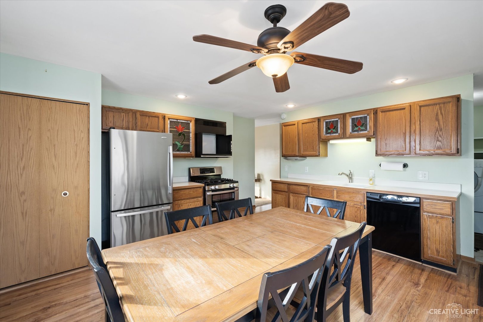 135 Heathgate Road Montgomery, IL 60538 - Photo 6 of 17 a kitchen with stainless steel appliances granite countertop a refrigerator a stove a sink a dining table and chairs with wooden floor