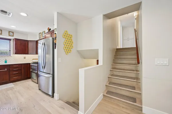 a large kitchen with stainless steel appliances kitchen island granite countertop a sink refrigerator and cabinets