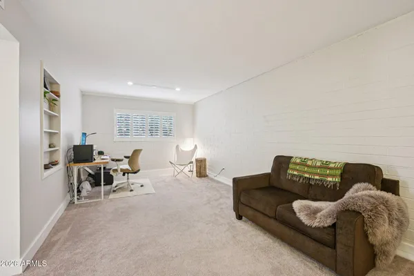a bedroom with a bed table and a window