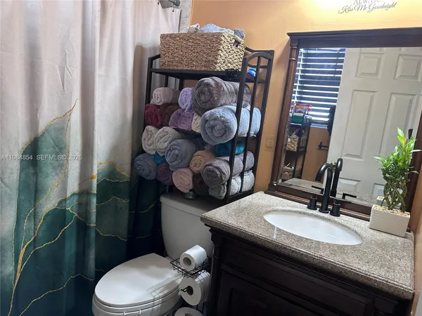 a bathroom with a toilet and a shower curtain