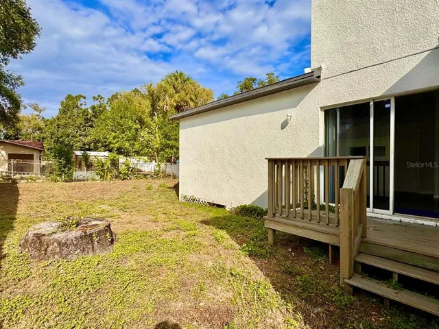 a view of a back yard with a wooden fence