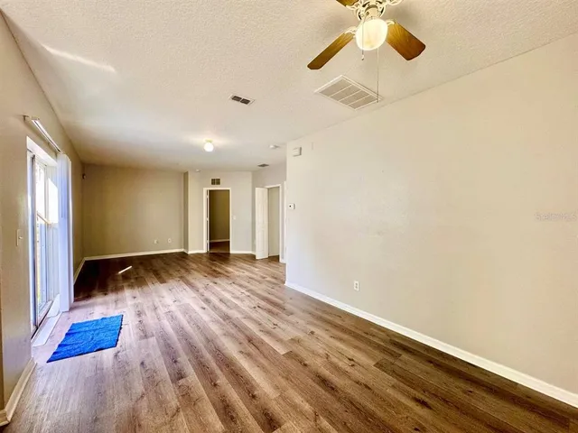 a view of empty room with wooden floor