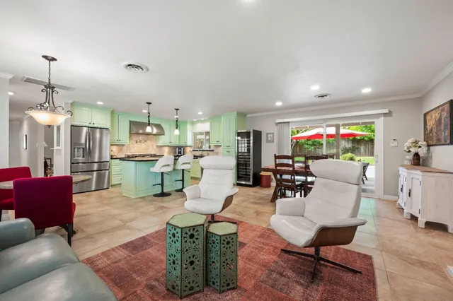 a living room with furniture kitchen view and a chandelier