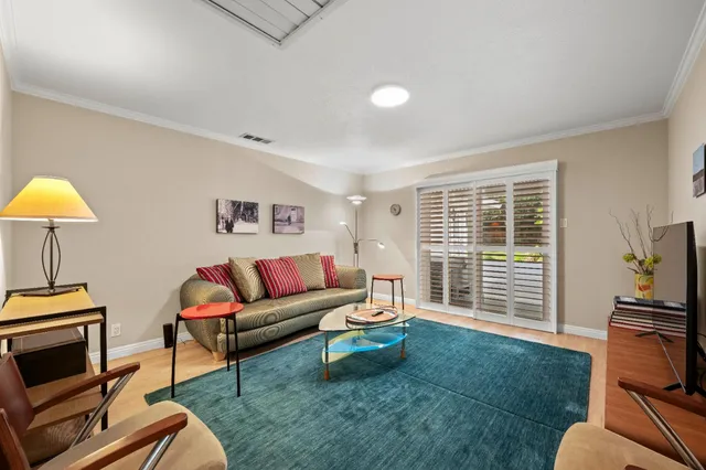 a living room with furniture a flat screen tv and a window