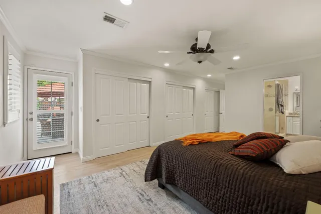 a bedroom with a large bed and wooden floor