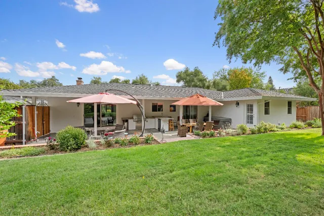 a view of a house with backyard sitting area and garden
