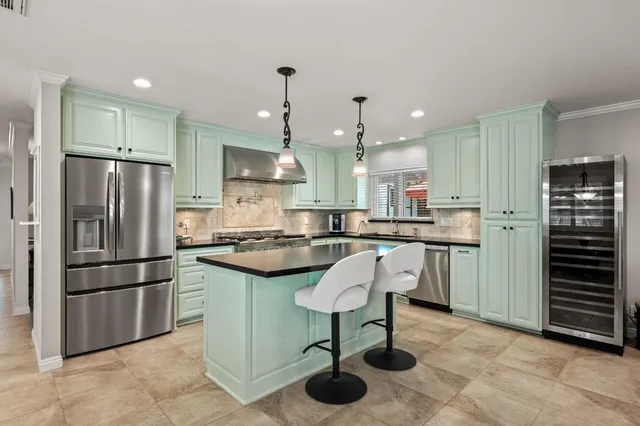 a kitchen with a refrigerator a oven and a sink