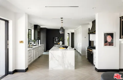 a kitchen with stainless steel appliances a dining table and chairs