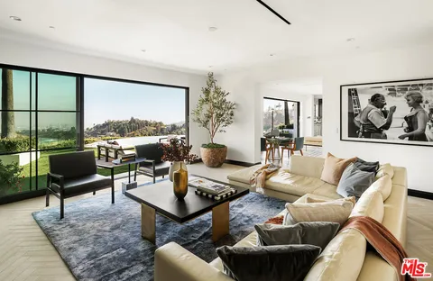 a living room with furniture a lamp a rug and a large window