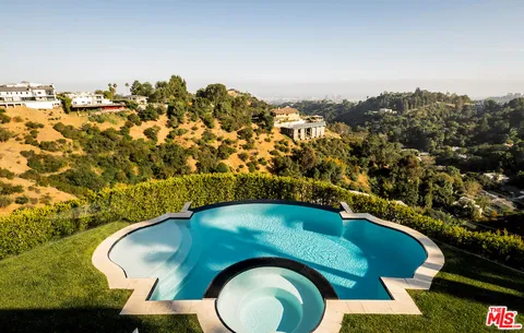 an aerial view of a house with a yard swimming pool and outdoor seating