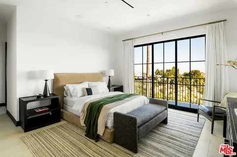 a living room with couches a flat screen tv and a table with wooden floor