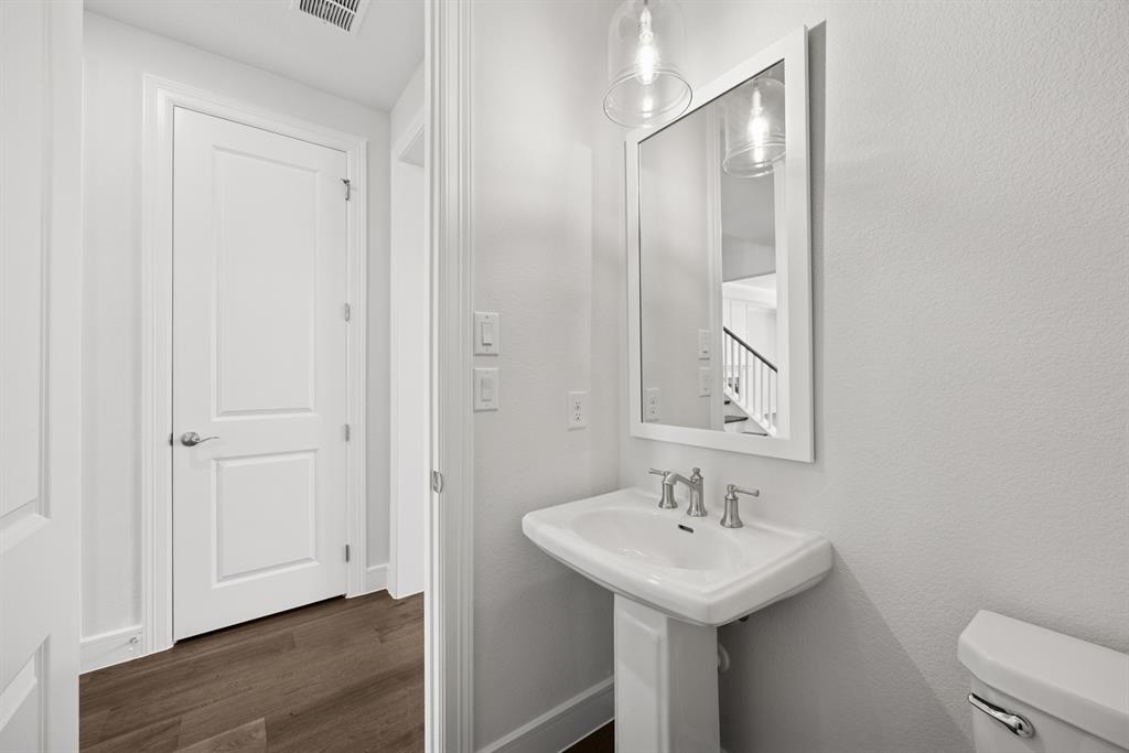 1317 Benjamin Trail Van Alstyne, TX 75495 - Photo 22 of 29 a bathroom with a sink a toilet and a mirror